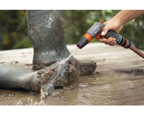 Cizmele de cauciuc murdare sunt curățate cu un pulverizator de curățare Gardena