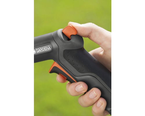 Prim-plan cu o mână care operează un furtun de grădină cu logo-ul Gardena