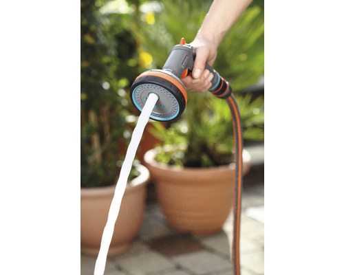 Persoană care ține un pulverizator multifuncțional Gardena cu jet de apă