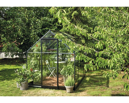 Seră cu plante și mobilier de grădină în grădină