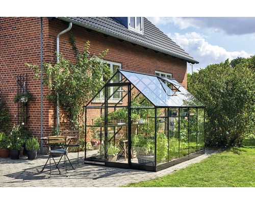 Seră în grădină cu plante și zonă de relaxare