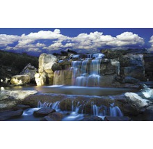 Cascadă artificială cu roci și plante sub cerul albastru