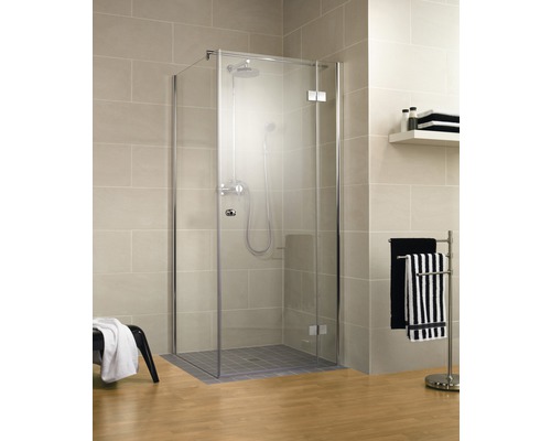 Cabină de duș pe colț cu armătură de duș și suport pentru prosoape într-o baie