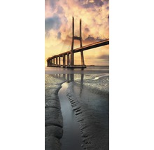 Podul Vasco da Gama traversează un râu la apus de soare.