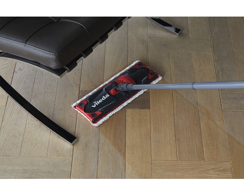 Mop Vileda pe parchet lângă un scaun