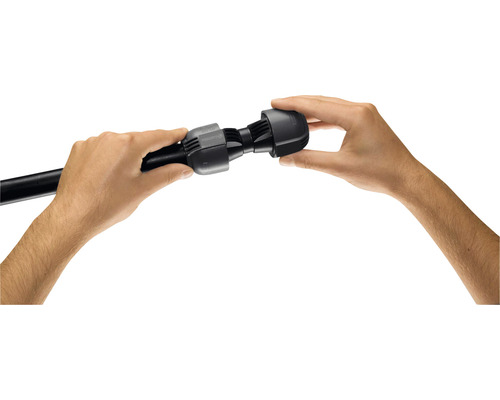 Două mâini montează un conector negru pe o țeavă neagră.