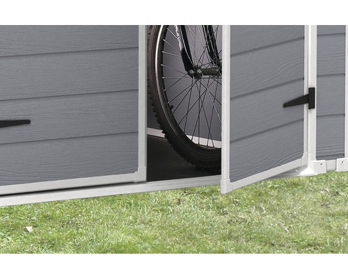 Prim-plan cu o magazie de grădină cu uși deschise și o bicicletă în interior