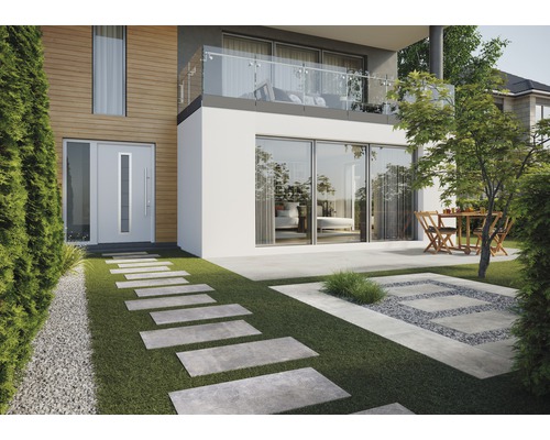 Fațadă de casă cu ușă de intrare, terasă cu zonă de relaxare și plăci de pavaj în grădină