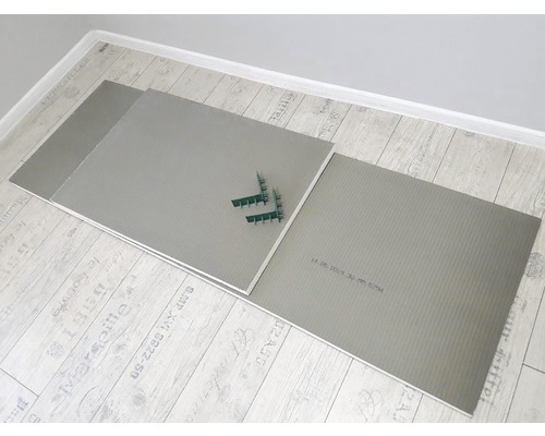 Plăci izolatoare din polistiren cu clipsuri de fixare pe o podea din lemn