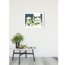Imagine decorativă cu soldații Star Wars Stormtroopers înrămată pe un perete deasupra unei mese cu o vază.