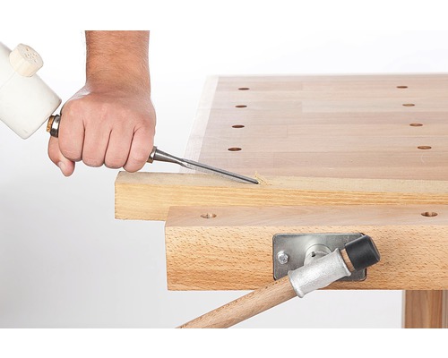 O persoană folosește o daltă pe un banc de lucru.