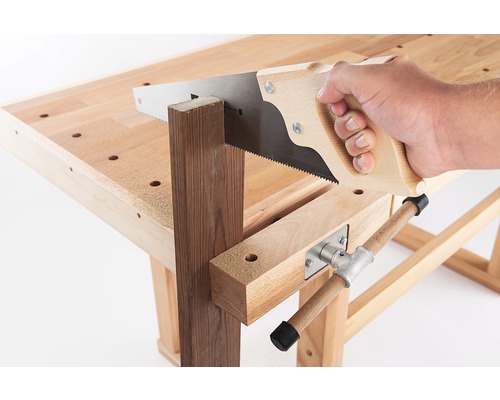 Mână cu fierăstrău taie o bucată de lemn pe bancul de lucru