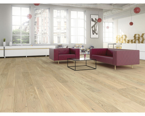 Living cu podea din lemn deschis, canapea roșie și ferestre mari