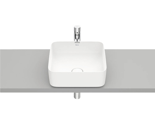 Lavoar ceramic pe blat, pe o suprafață gri, cu robinet