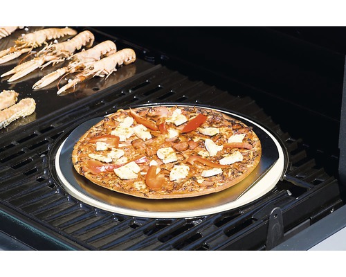 Pe un grătar se află o pizza pe o piatră de pizza, înconjurată de scampi.