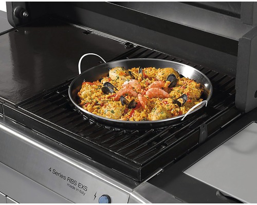 Paella într-o tigaie de paella pe un grătar pe gaz