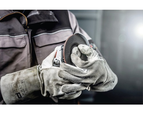 O persoană manevrează o polizor cu mănuși.