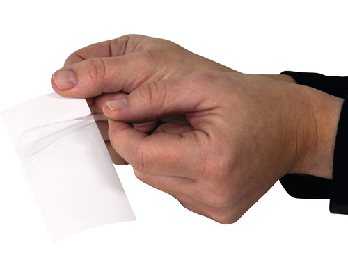 Mâini care îndepărtează folia de protecție de pe folia autoadezivă