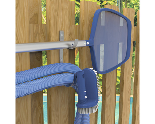 Accesorii de curățare a piscinei pe un perete de lemn, inclusiv plasă, perie și furtun