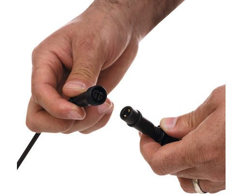 Două mâini țin un cablu de conectare negru.