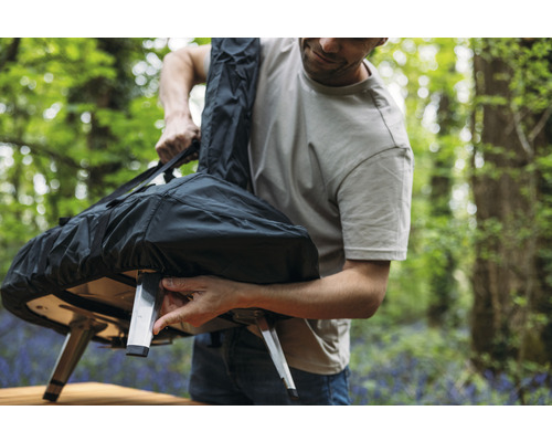 Bărbat depozitează cuptorul de pizza într-o geantă de transport în aer liber