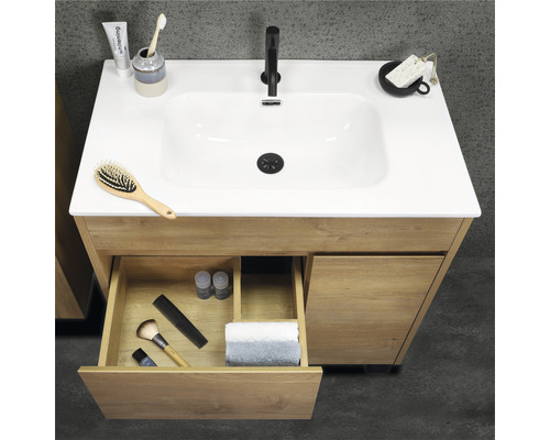 Dulap de bază din lemn pentru lavoar cu sertar deschis și diverse articole de baie pe chiuvetă