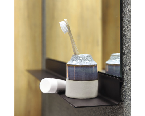 Scenă de baie cu suport pentru periuța de dinți, periuță de dinți și produs cosmetic pe un raft