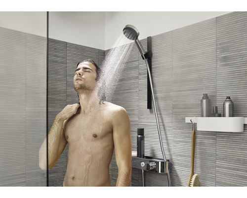 Bărbat sub un duș de mână într-o baie modernă