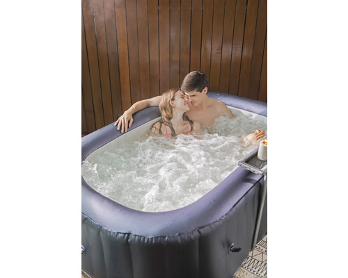 Un cuplu se relaxează într-un jacuzzi gonflabil