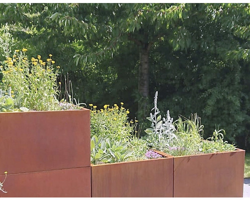 Jardiniere metalice stivuite, plantate în grădină.