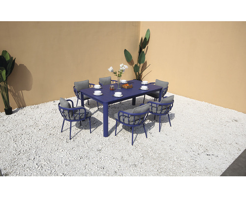 Scenă de grădină cu masă de sufragerie albastră și scaune cu perne gri pe pietriș