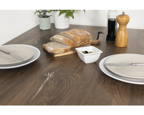 Masa de sufragerie cu pâine feliată, măsline, veselă și decorațiuni