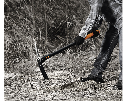 O persoană lucrează cu un târnăcop pentru a pregăti solul.