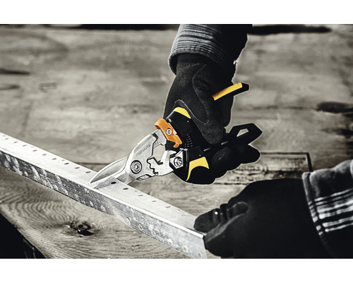 O persoană taie un profil metalic cu o foarfecă de tablă.