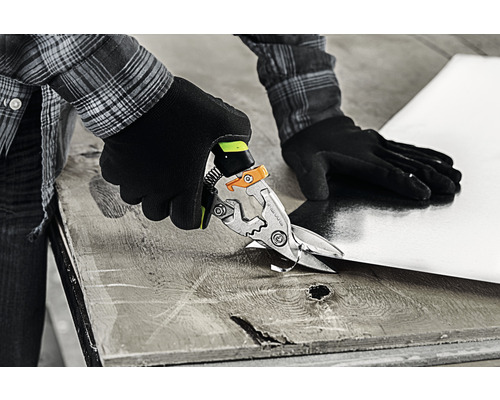 O persoană taie o foaie de tablă cu foarfecele de tablă