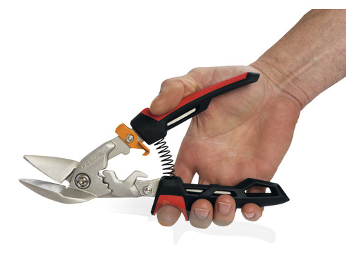 O mână ține o foarfecă de tablă.