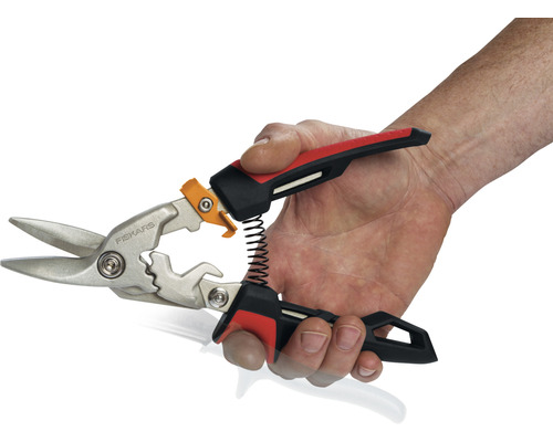 O mână ține o foarfecă de tablă marca Fiskars.