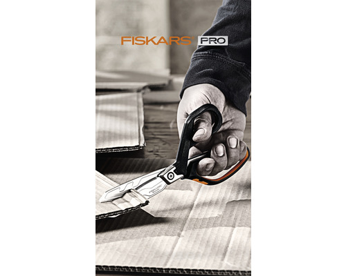 O mână taie carton cu o foarfecă Fiskars Pro.