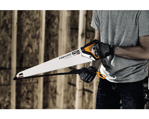 Persoană care ține un ferăstrău manual marca Fiskars Pro