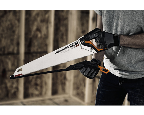 Persoană care ține un fierăstrău manual Fiskars.