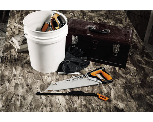 Scenă cu un fierăstrău pentru metal, o găleată, o cutie de scule și mănuși de lucru