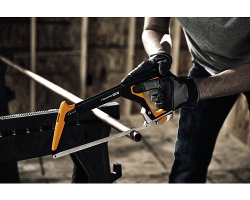 Un fierăstrău cu arc Fiskars Pro taie o țeavă.