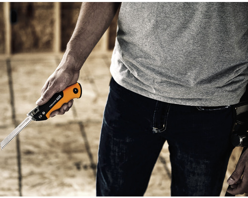 Bărbat ținând un ferăstrău coadă de șobolan marca Fiskars