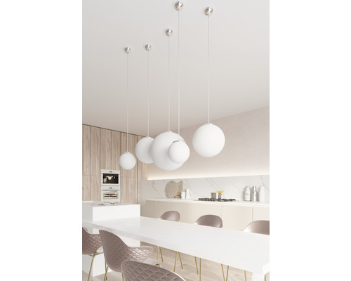 Bucătărie luminoasă cu masă de dining și mai multe lămpi suspendate rotunde