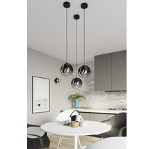 Trei lămpi suspendate negre deasupra unei mese rotunde într-o bucătărie.