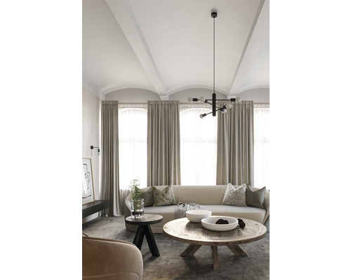 Cameră de zi cu canapea, perdele, măsuțe de cafea și corp de iluminat suspendat