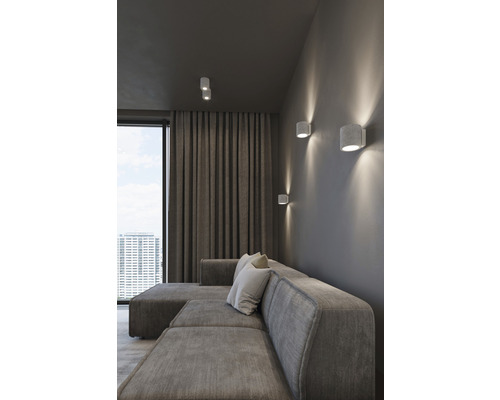 Sufragerie cu canapea din stofă, perdele și lămpi de perete