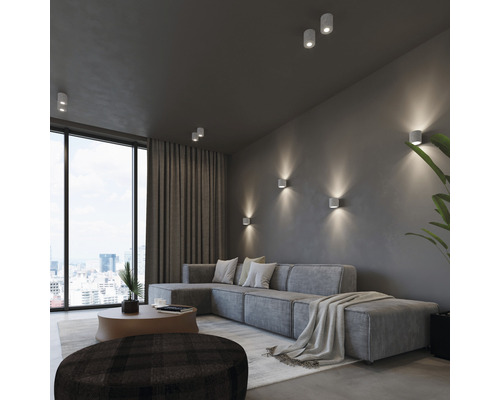 Cameră de zi cu canapea, fereastră și lămpi de tavan și lămpi de perete