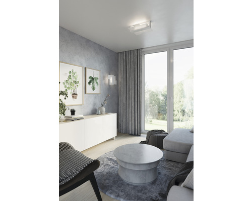 Cameră de zi cu locuri de ședere, măsuță de cafea, bufet, plafonieră și decorațiuni.