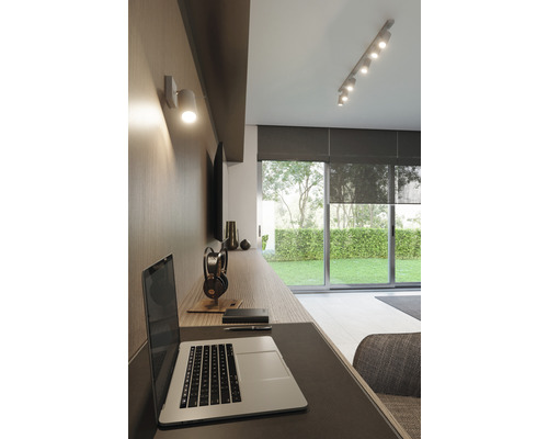 Birou modern cu birou, laptop, lampă de perete și spoturi de tavan
